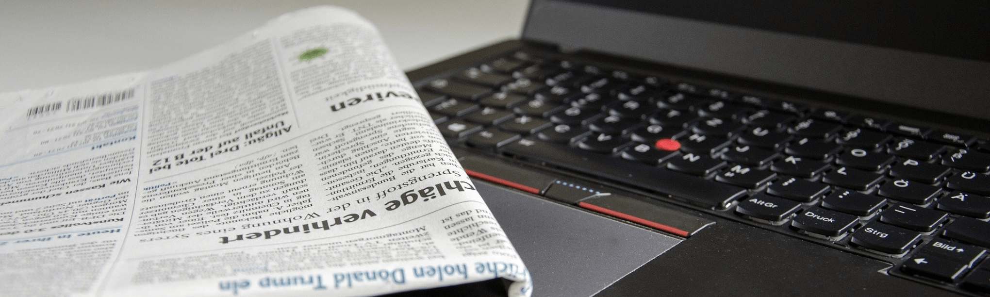 A Black Color Laptop With a Newspaper